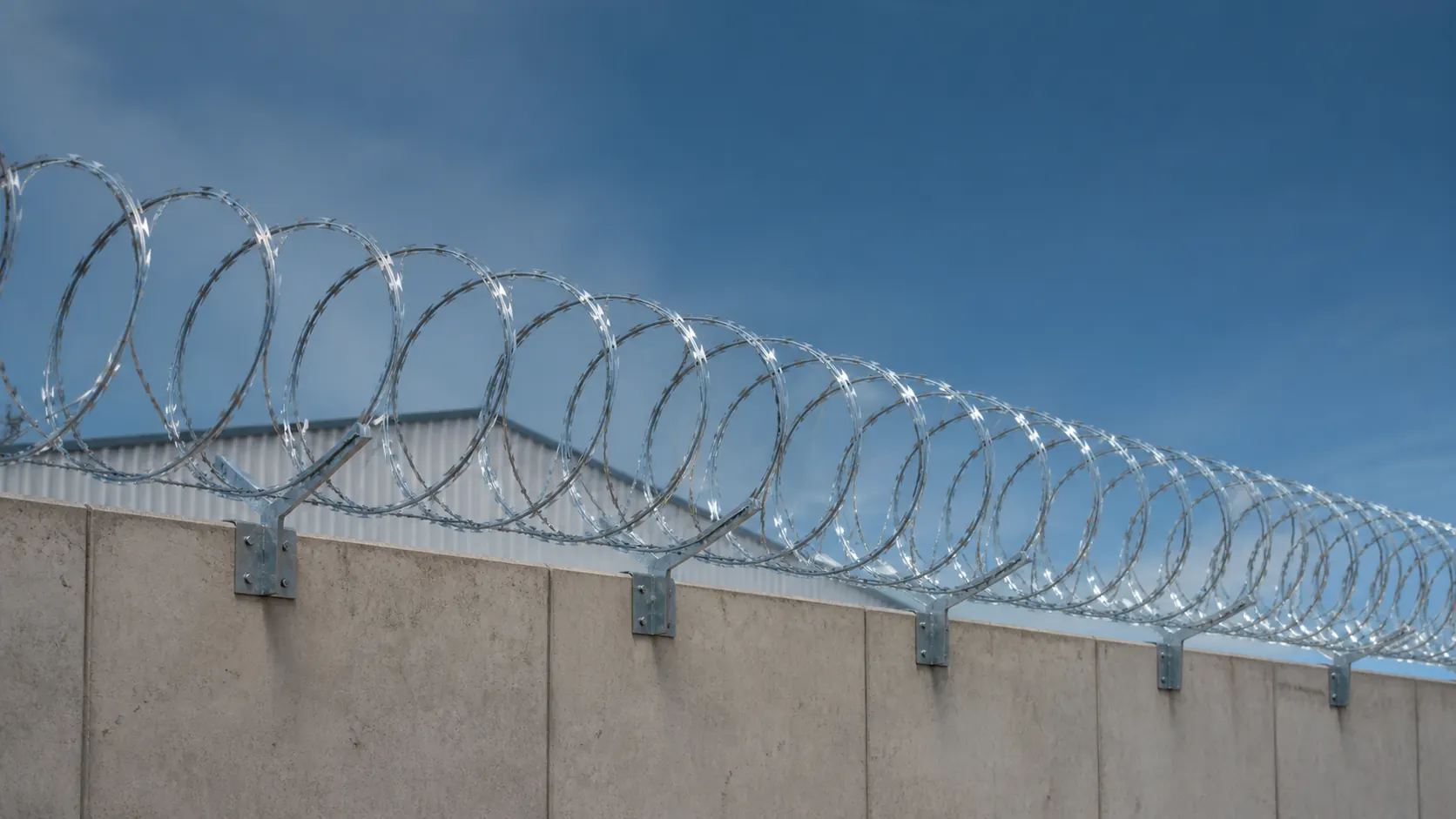 Concertina galvanizada instalada sobre el muro perimetral de una propiedad industrial